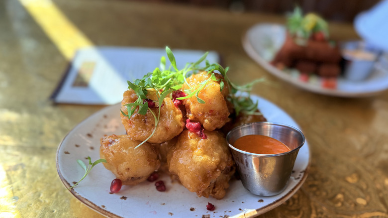pomegranate-chili crispy cauliflower on a table at Spice Road Table