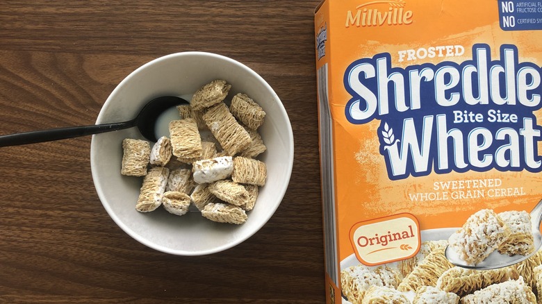 Bowlful of Millville frosted shredded wheat cereal with milk and spoon.