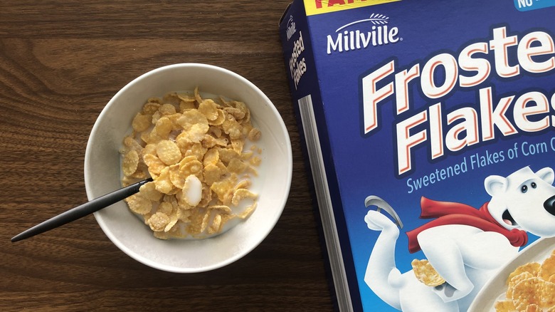 Bowlful of Millville Frosted Flakes with milk and spoon.