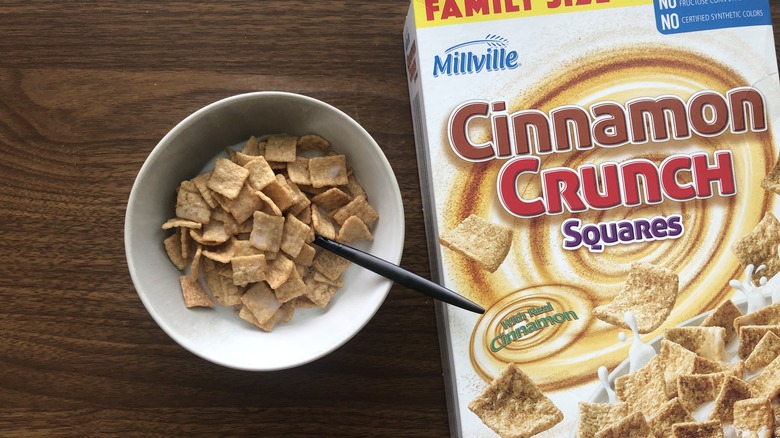 Bowlful of Millville Cinnamon Crunch Squares with milk and spoon.