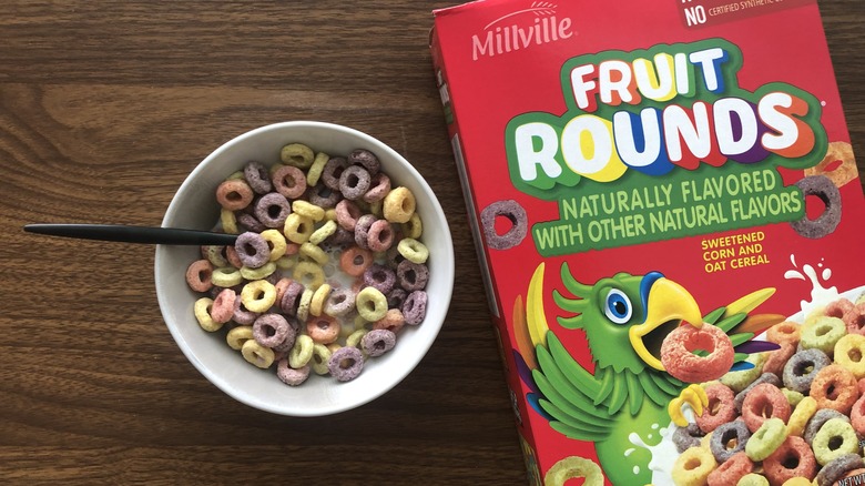 Bowlful of Millville Fruit Rounds with milk and spoon.