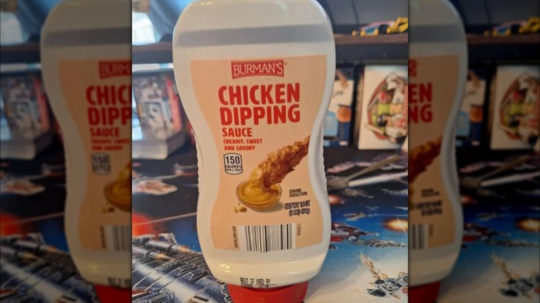 A squeeze bottle of Burman's chicken dipping sauce with a pale peach label and red text