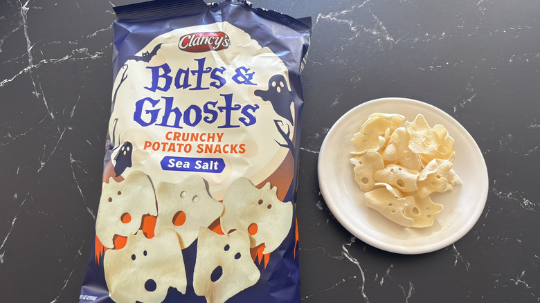A bag of Clancy's Bats & Ghosts Crunchy Potato Snacks next to ghost-shaped chips on a white plate