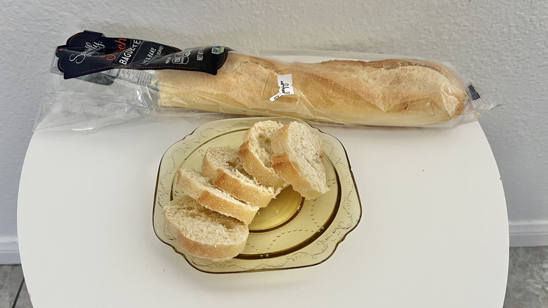 Aldi baguette whole with several slices on plate in front
