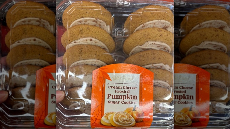 A plastic container of Aldi Bake Shop Cream Cheese Frosted Pumpkin Sugar Cookies