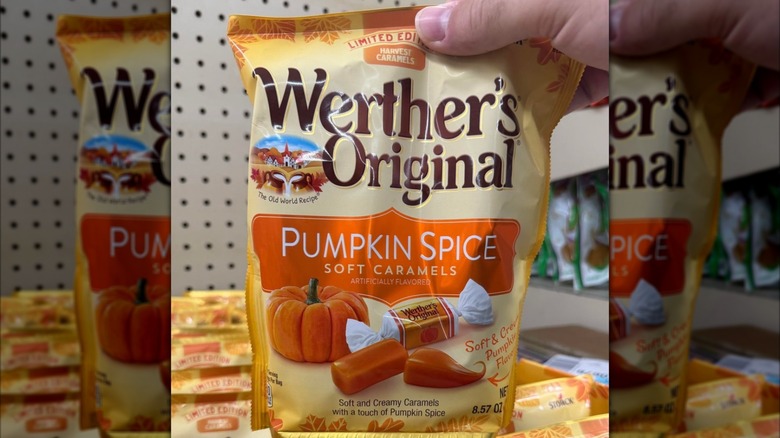 A person holding up a bag of Werther's Original Pumpkin Spice Soft Caramels