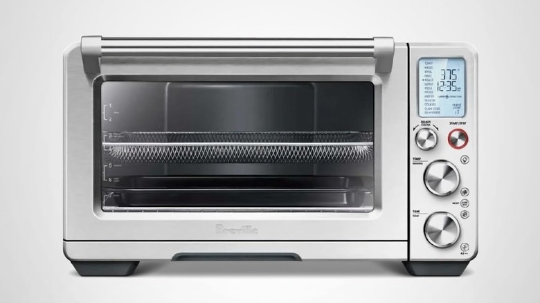 A silver air fryer/convection oven with a digital display on white background