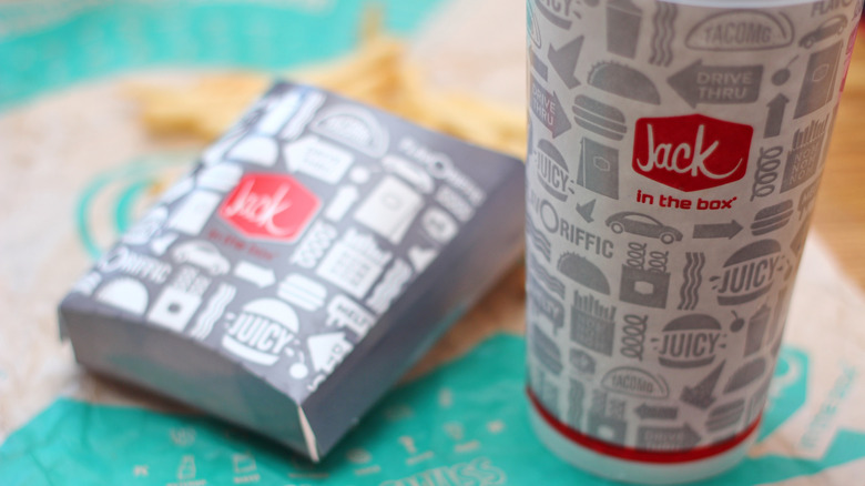 A box of Jack in the Box fries next to a Jack In The Box drink cup
