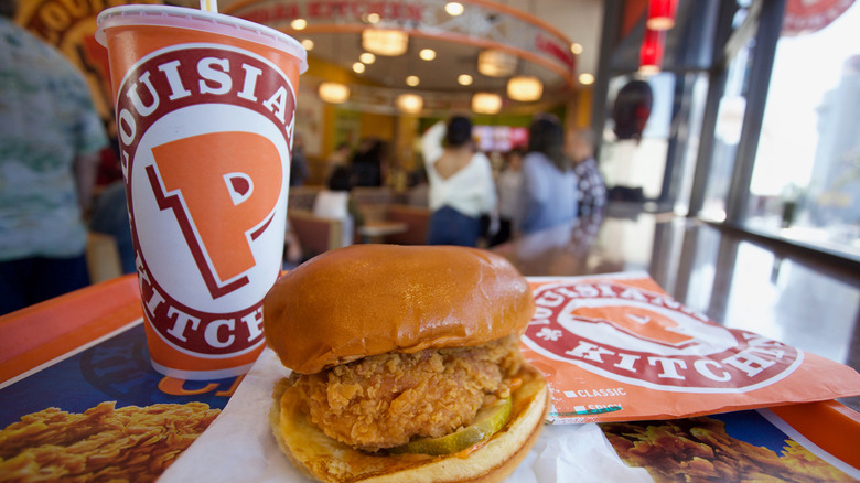 Popeyes Chicken Sandwich on a tray next to a Popeyes drink cup