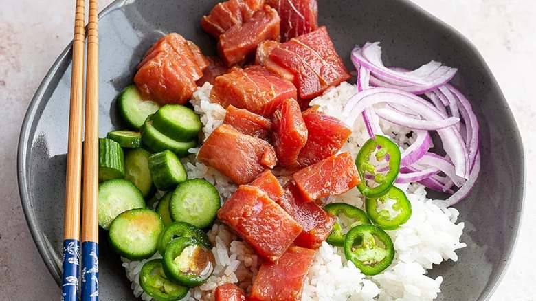 A poke bowl with ahi tuna, cucumber, rice, and more