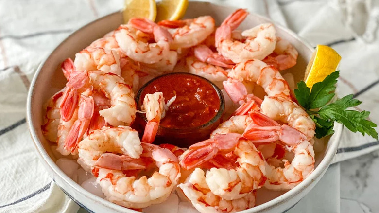 A bowl of shrimp cocktail with the red sauce at the center