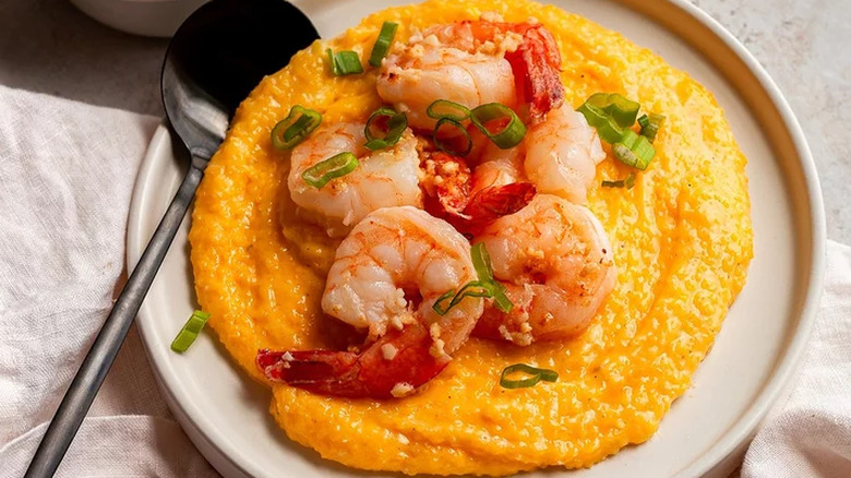 A plate of shrimp topped grits with scallions