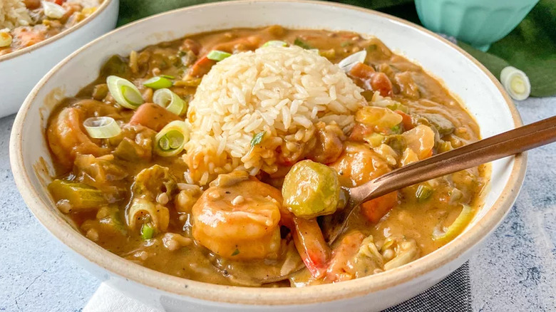 A bowl of shrimp and okra gumbo with a mound of white rice in the middle