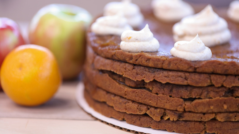 Spiced apple and ginger stack cake with fruit in background