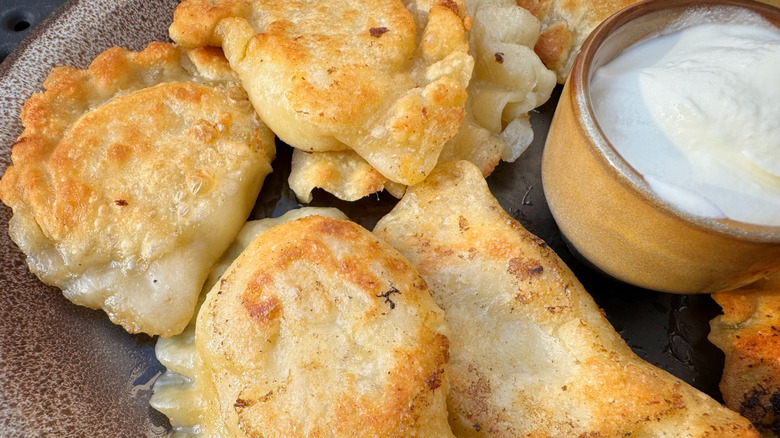 Pierogis on plate with sour cream