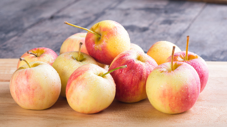 Whole Fuji apples on chopping board
