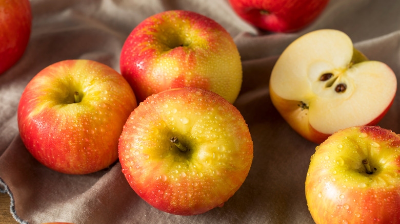 Whole and sliced Honeycrisp apples on cloth