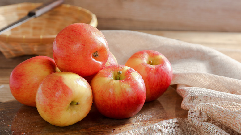 Whole Jazz apples on a table with a cloth