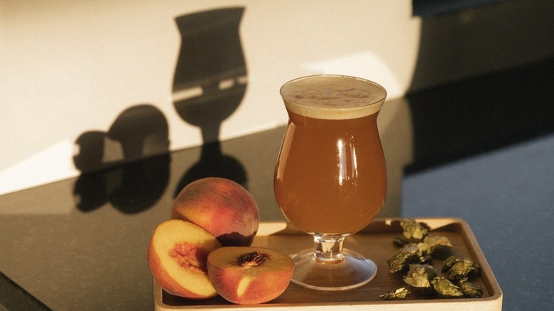 Coffee drink with peaches on tray with their shadows on wall at Coffea Rosterie