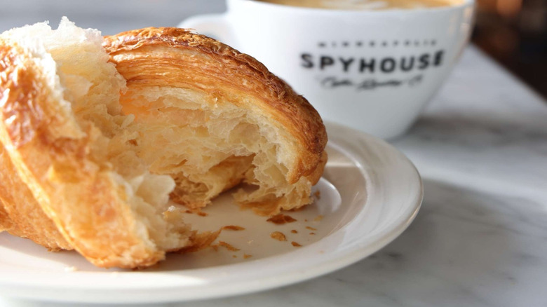 Croissant bits with Spyhouse-labeled coffee cup