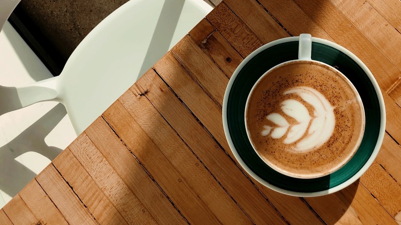 Top view of latte cup on wooden table at The Roosevelt Coffeehouse