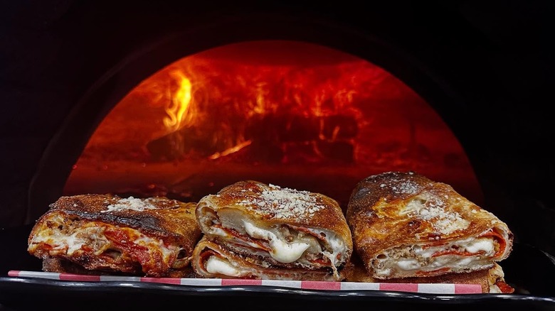 Food from DaVinci's Brick Oven Pizza in front of a brick oven