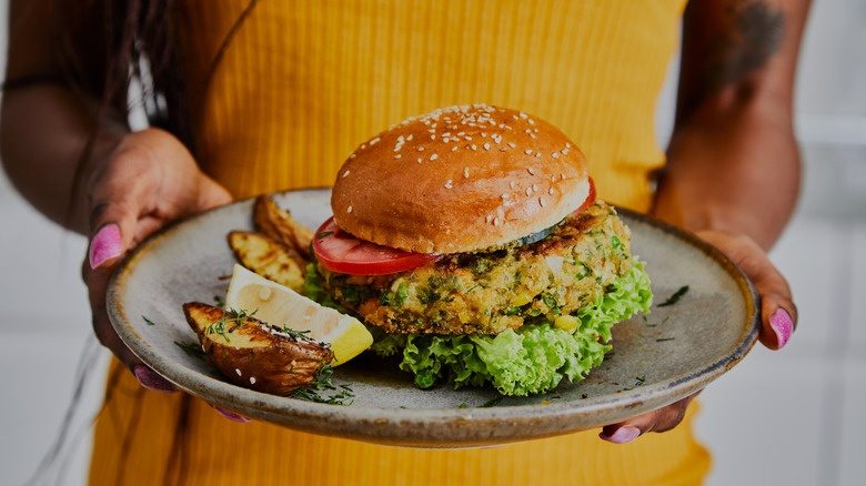 Woman holding vegan burger