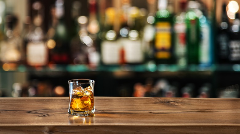 A glass of whiskey on a bar counter