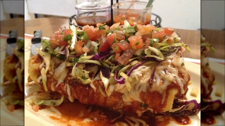 Chimichanga covered with sauce, cheese, and pico