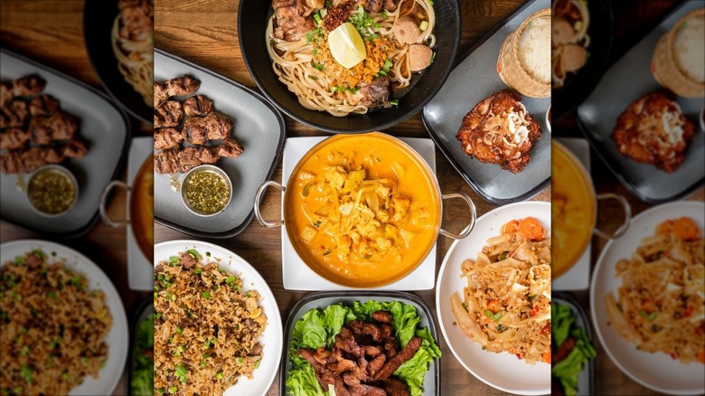 Assortment of dishes including curry, rice, and skewers