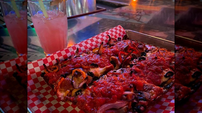 Detroit-style pizza on tray with drink in the background