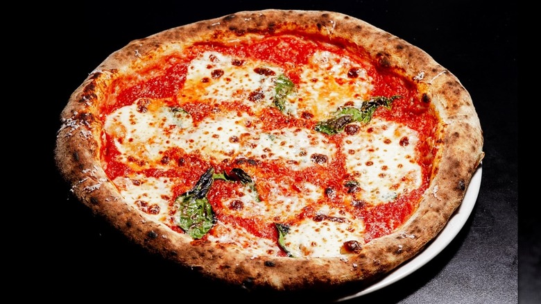 Wood-fired Magherita pizza on black background