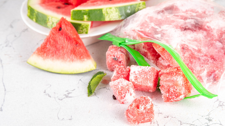 Frozen watermelon cubes in front of frozen watermelon slices.