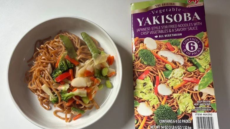 Ajinomoto yakisoba with vegetables in a bowl next to a paper package of the same dish