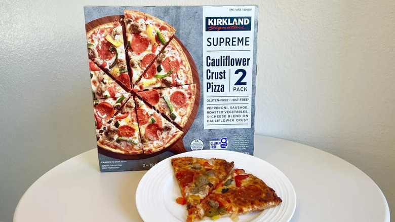 Kirkland Signature supreme cauliflower crust pizza slice on a plate with a whole box in the back