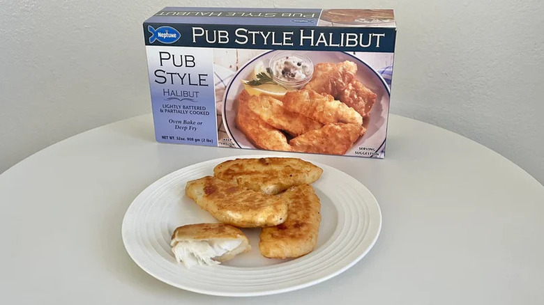 Box of Neptune pub style halibut with cooked pieces assembled on a plate in front
