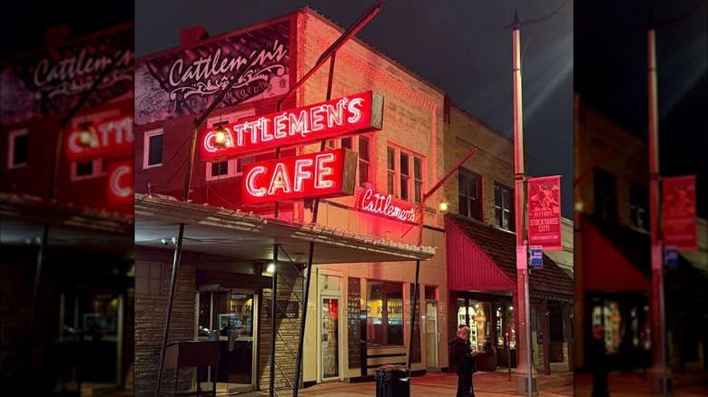 Exterior of Cattlemen's building at night lit by neon signs