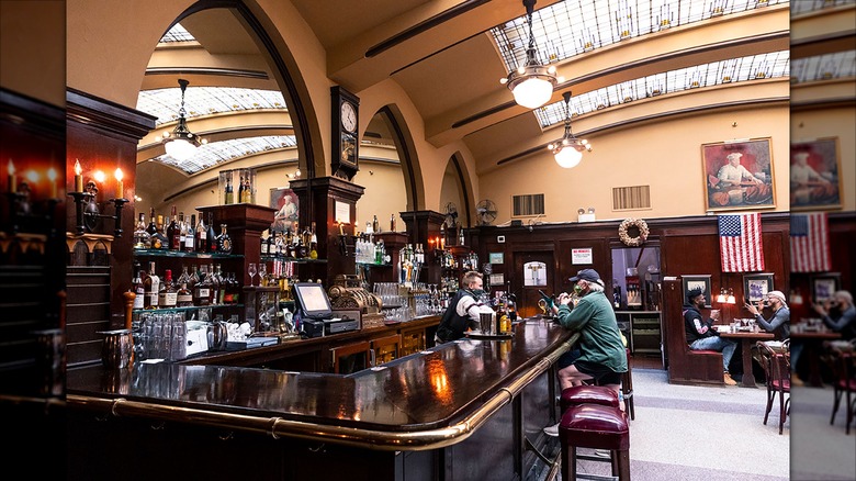 Bar in Huber's with high vaulted ceilings and a bartender waiting on a patron