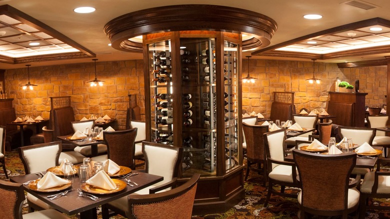 Stone-walled dining room with tables and rotating wine cabinet in the center