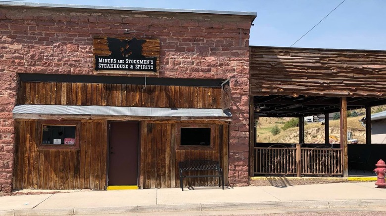 Exterior of Miners brick and wood building on a sunny day