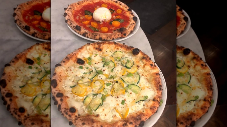 Two farm-fresh pizzas on a white counter