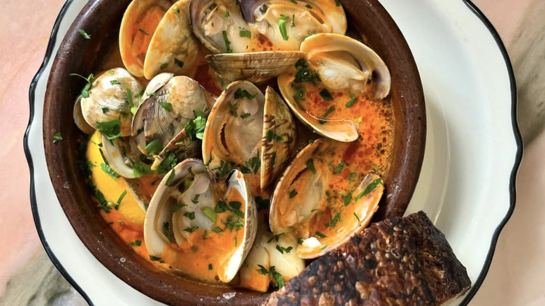 a close up of clams in a broth with bread