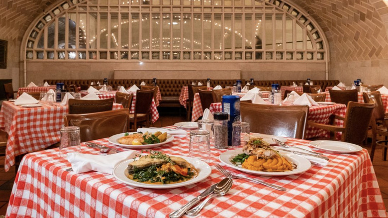 red checkered table cloths and wooden chairs with seafood on white plates
