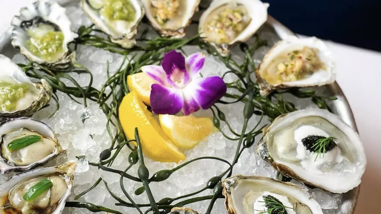 raw oysters on a bed of ice with garnish