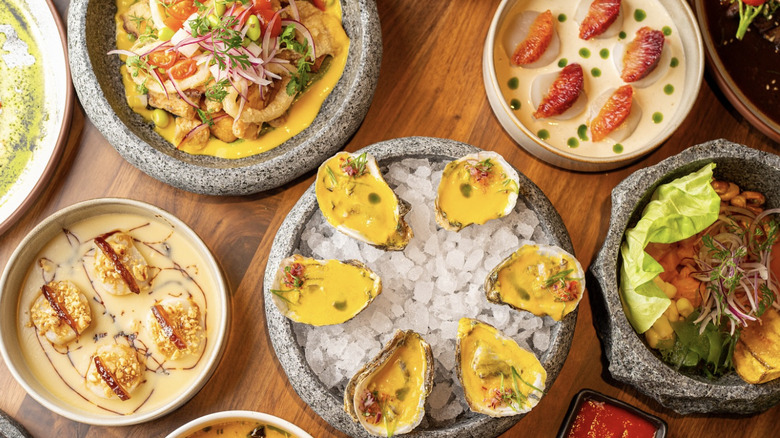 stone dishes with assorted bright colored seafood, including oysters and shrimp