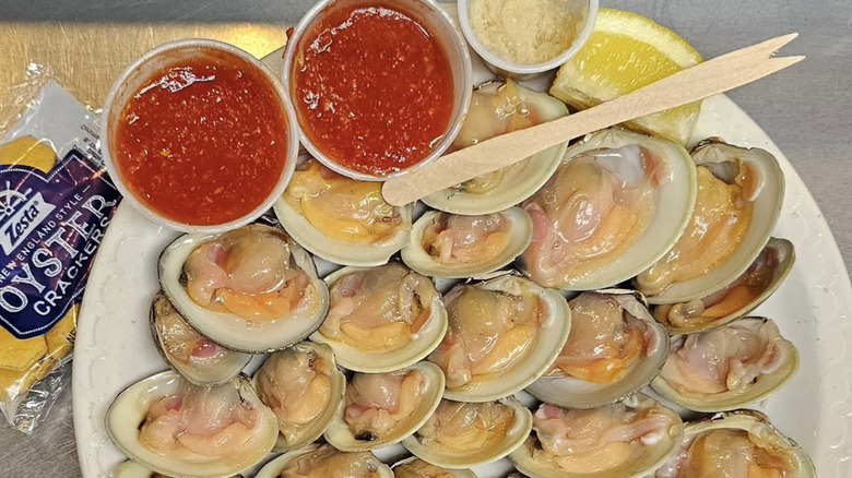 a plate of clams with red sauce on the side