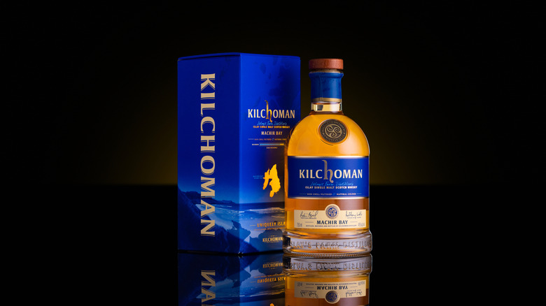 A stylized shot of a bottle of Kilchoman Machir Bay and its box with a black background