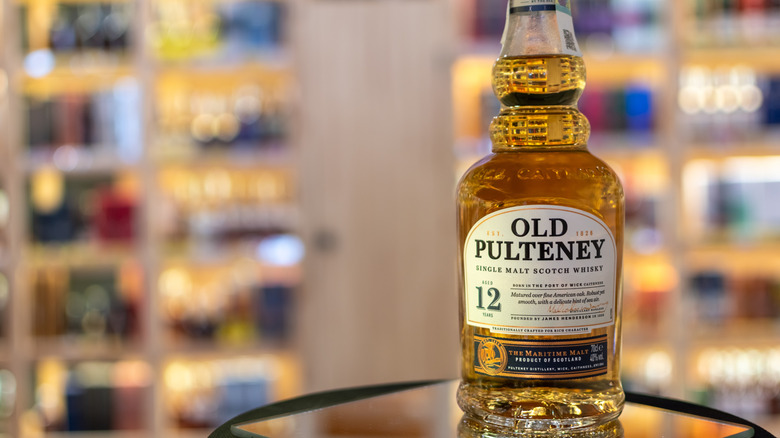 A bottle of Old Pulteney 12-year posed in a liquor store with blurred bottles in the background