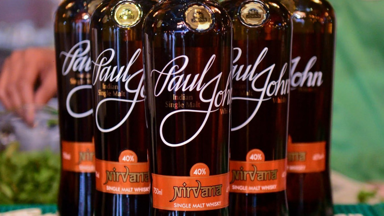 Bottles of Paul John Nirvana single malt whisky posed in a triangle formation for a product shot