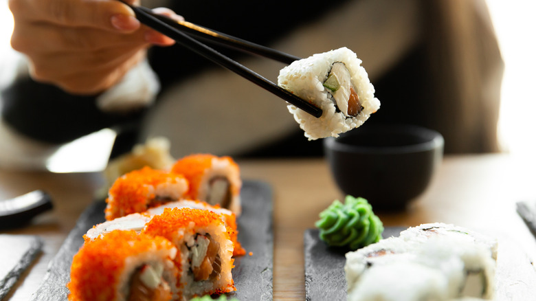Chopsticks holding sushi